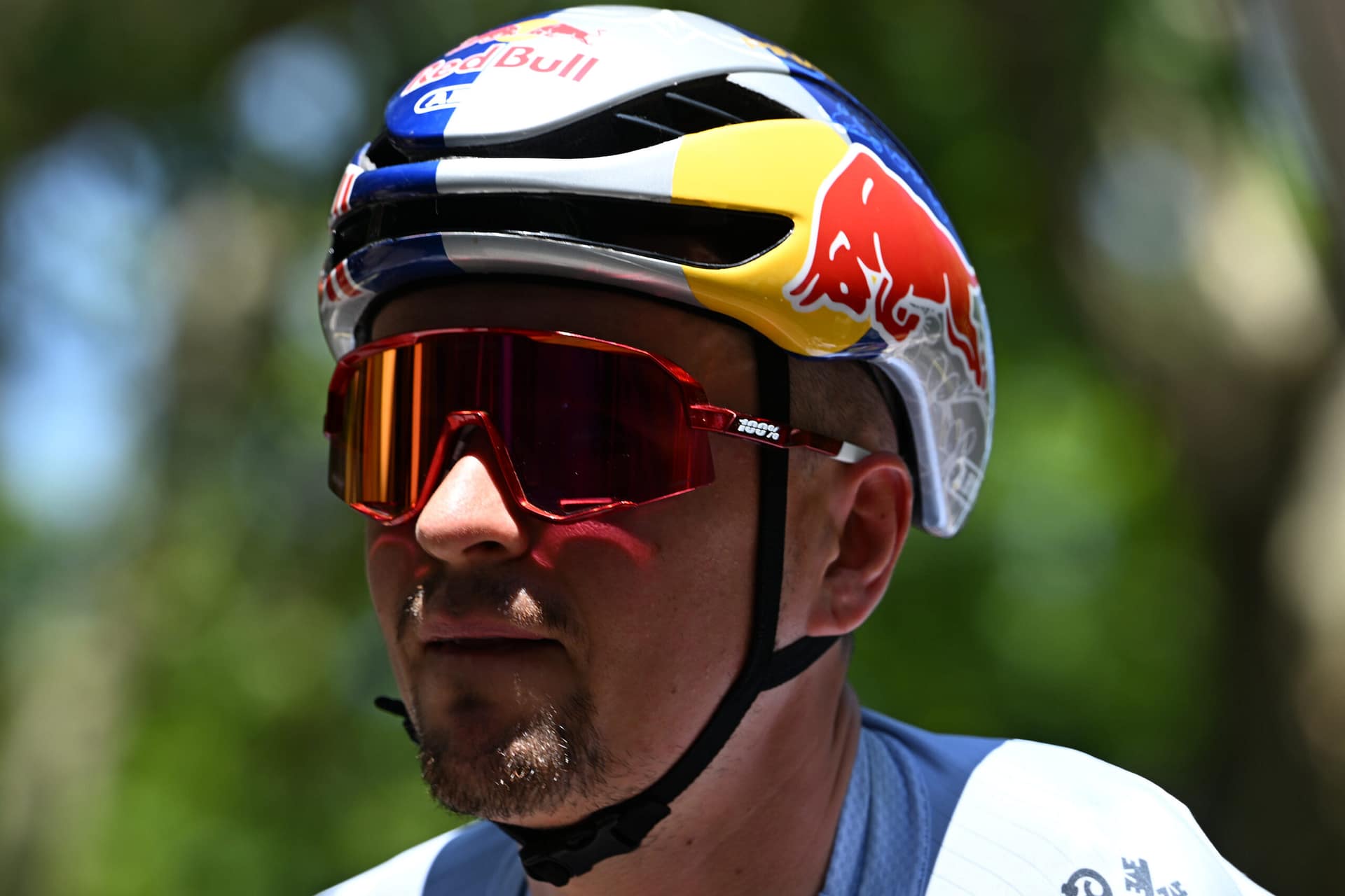 Remco Evenepoel draagt een Red Bull-helm en rode wielerbril tijdens een koers.