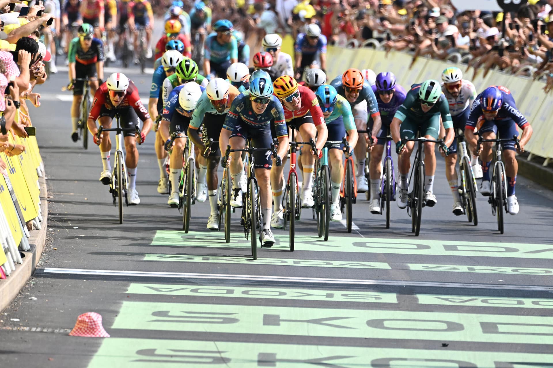 Peloton sprinting hard up the road at the Tour de France stage in Hagetmau toward Bordeaux