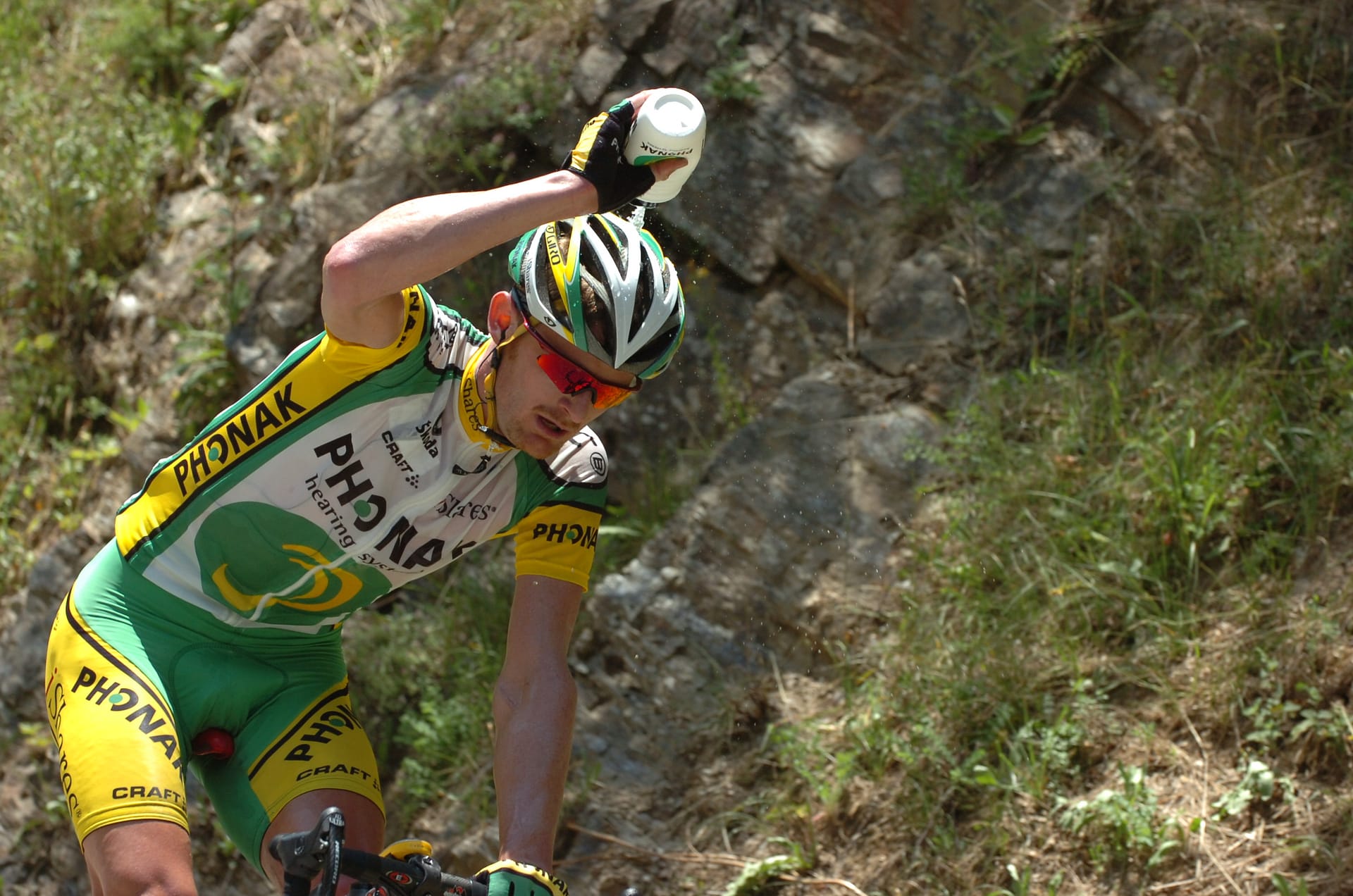 Cyclist in Phonak team jersey climbs a mountain road during the Tour de France at the Col de Saisies