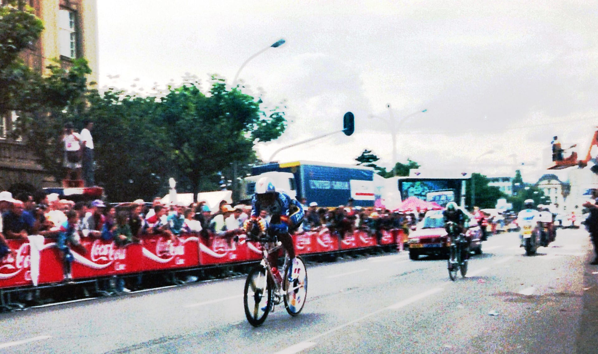 Cyclist in red-and-white peloton rides past crowds during the Tour de France in Luxembourg